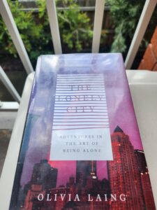 Photograph of book The Lonely City, taken outside in a garden